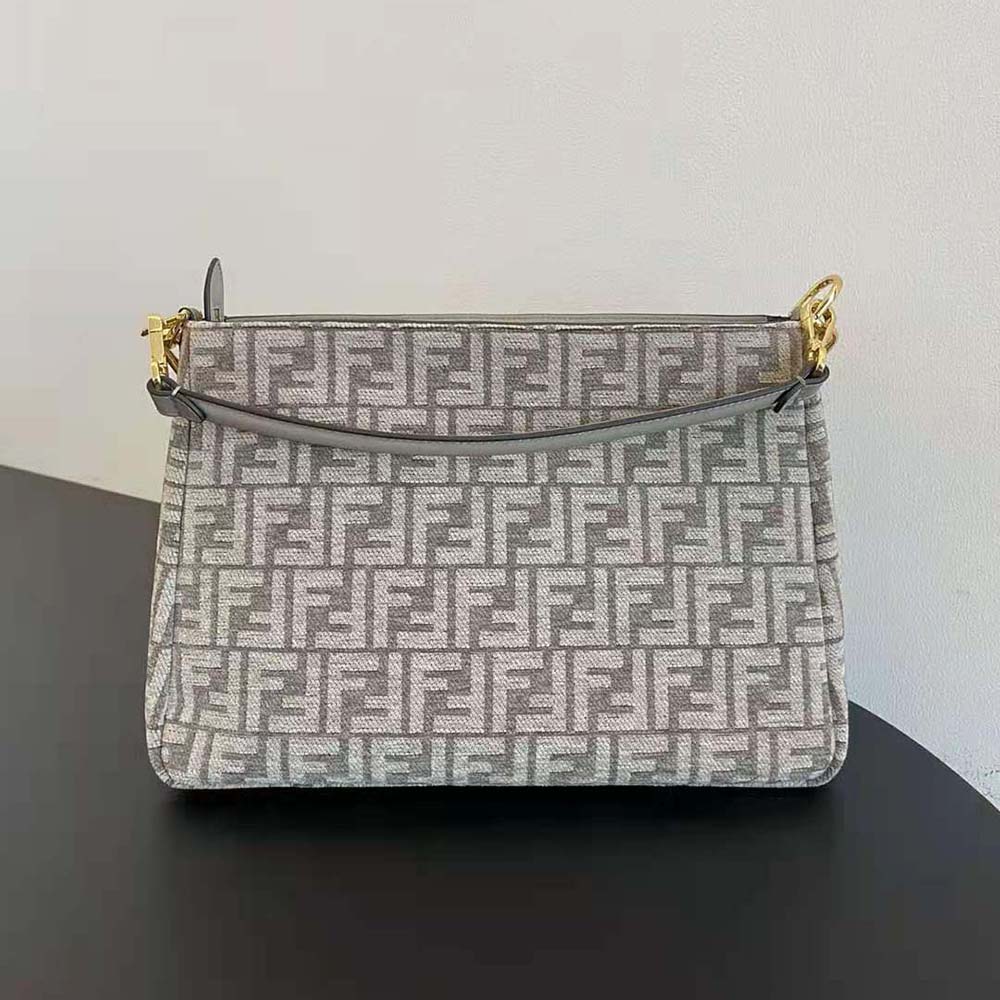 Side profile showing gold hardware and strap of Fendi tapestry bag
