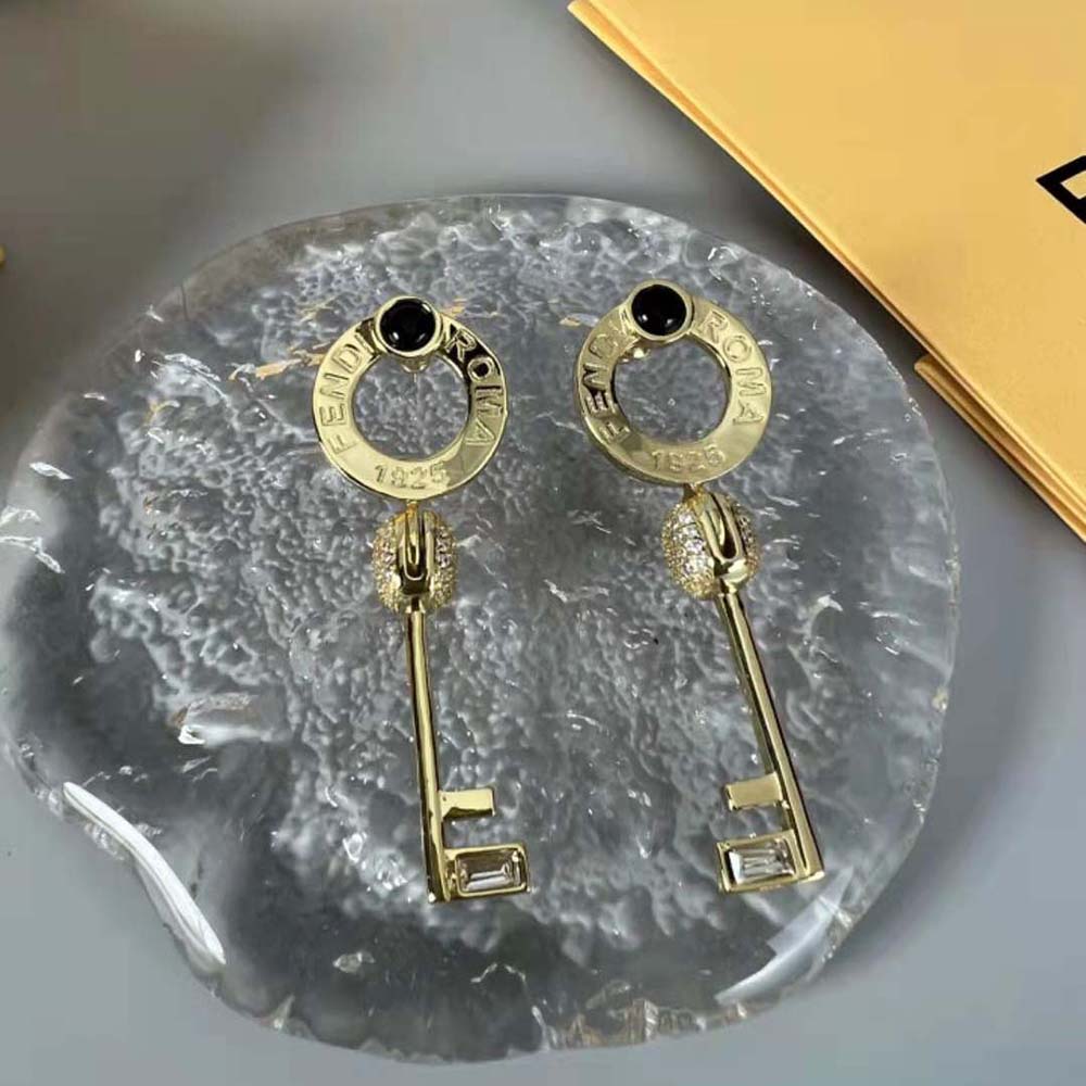 Close-up of gold-colored Master Key motif on Fendi earrings