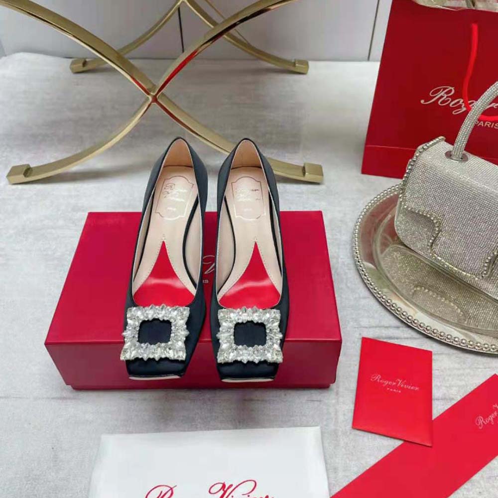 Close-up on rhinestone buckle detail of Roger Vivier black satin pumps