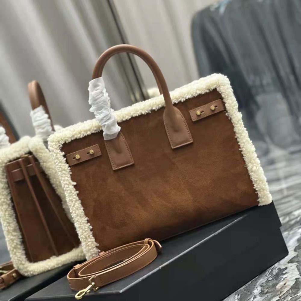 Close-up detail of matte gold YSL hardware on brown shearling bag