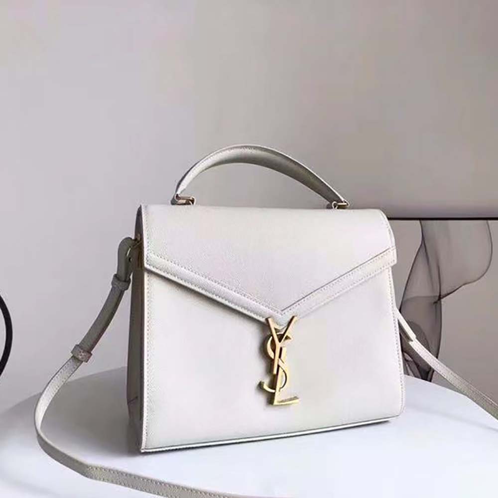 Close-up of white leather texture and antique gold YSL logo detail