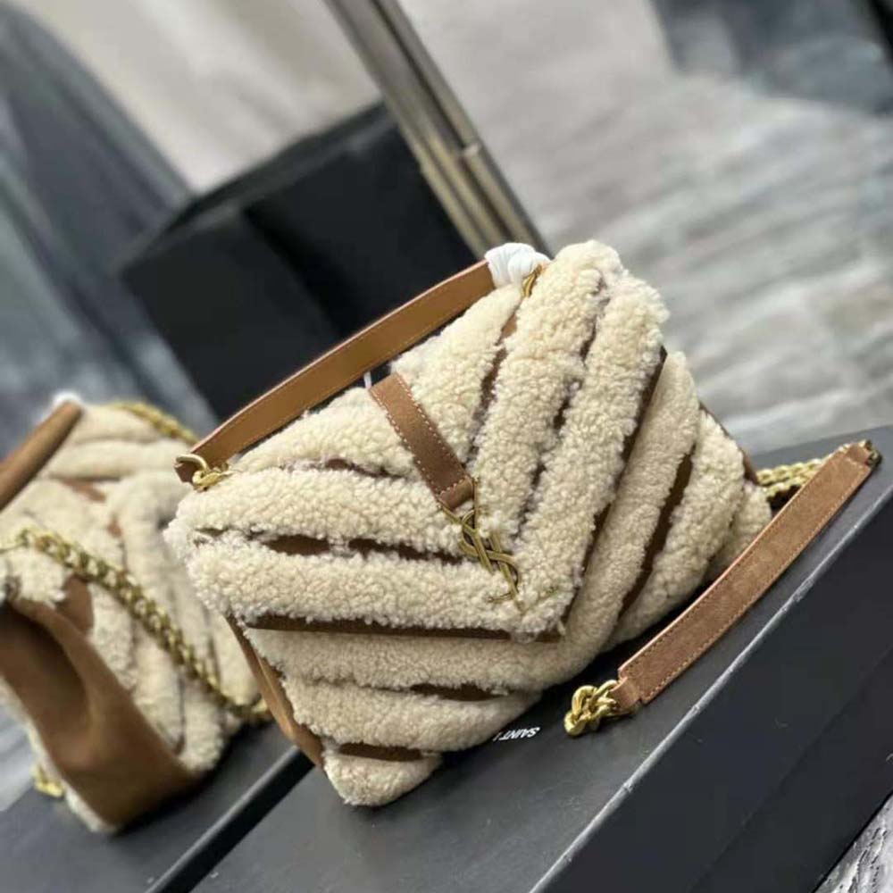 Side angle showing shearling trim and flap closure on Saint Laurent bag