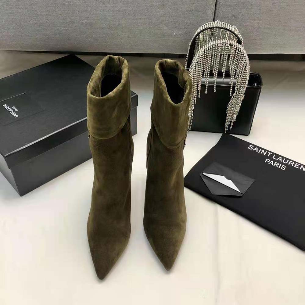 Close-up of silver-tone YSL monogram on green suede booties