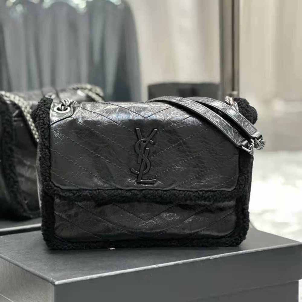 Close-up of YSL gold logo and crinkled leather texture on Niki medium bag