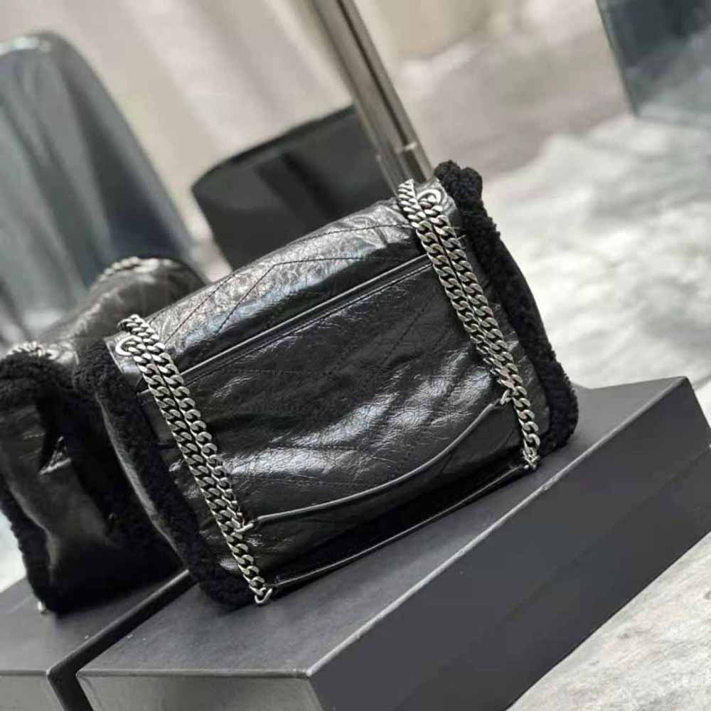 Side angle showing shearling lining and chain strap of Saint Laurent YSL Niki bag