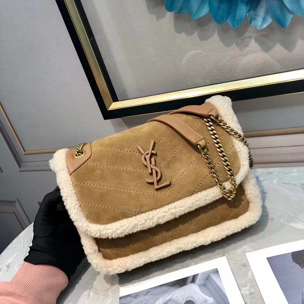 Close-up of gold chain strap and shearling trim on Saint Laurent YSL bag