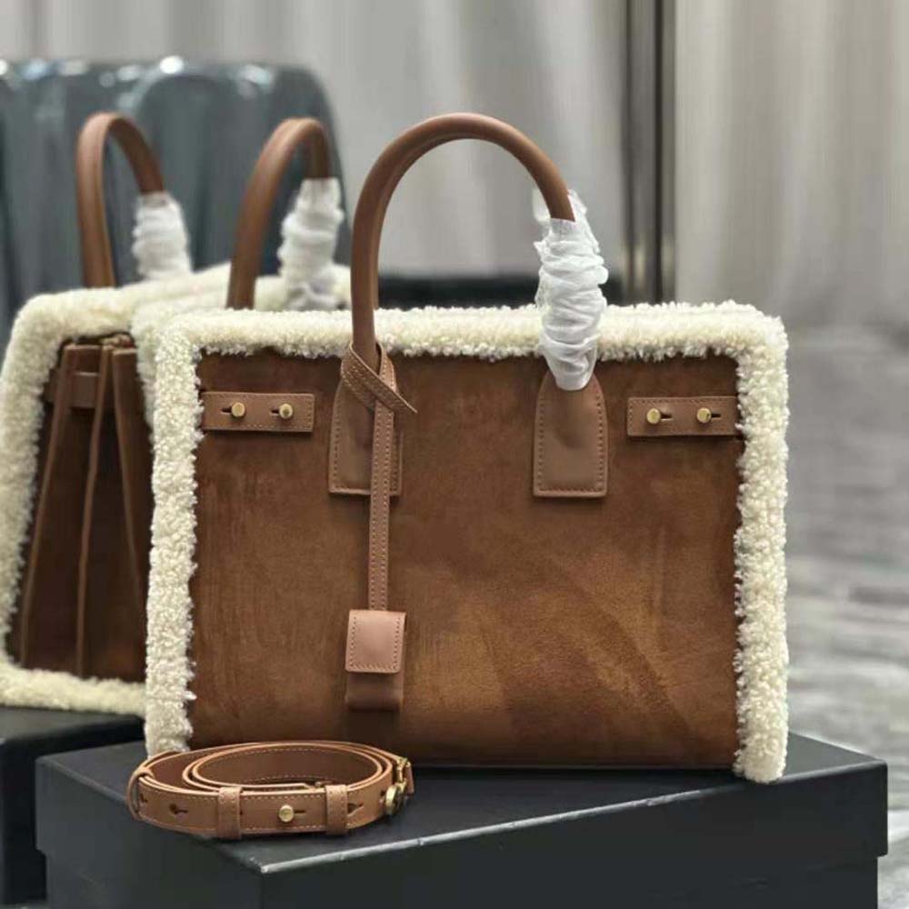 Close-up on gold YSL hardware and shearling trim on Saint Laurent bag