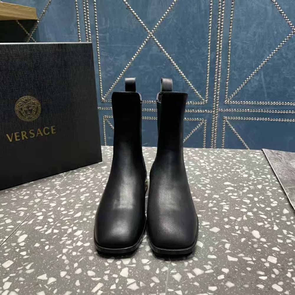Close-up of gold-tone Greca hardware on Versace Women Greca Chelsea Boots
