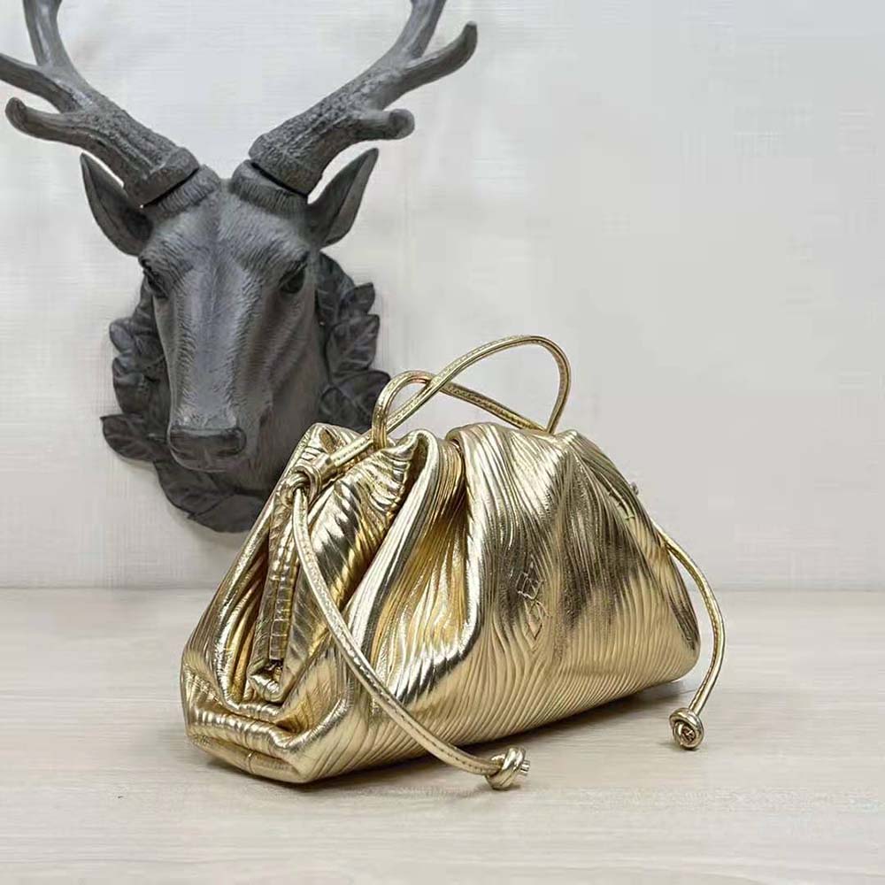 Side angle showing slim silhouette of Bottega Veneta gold clutch