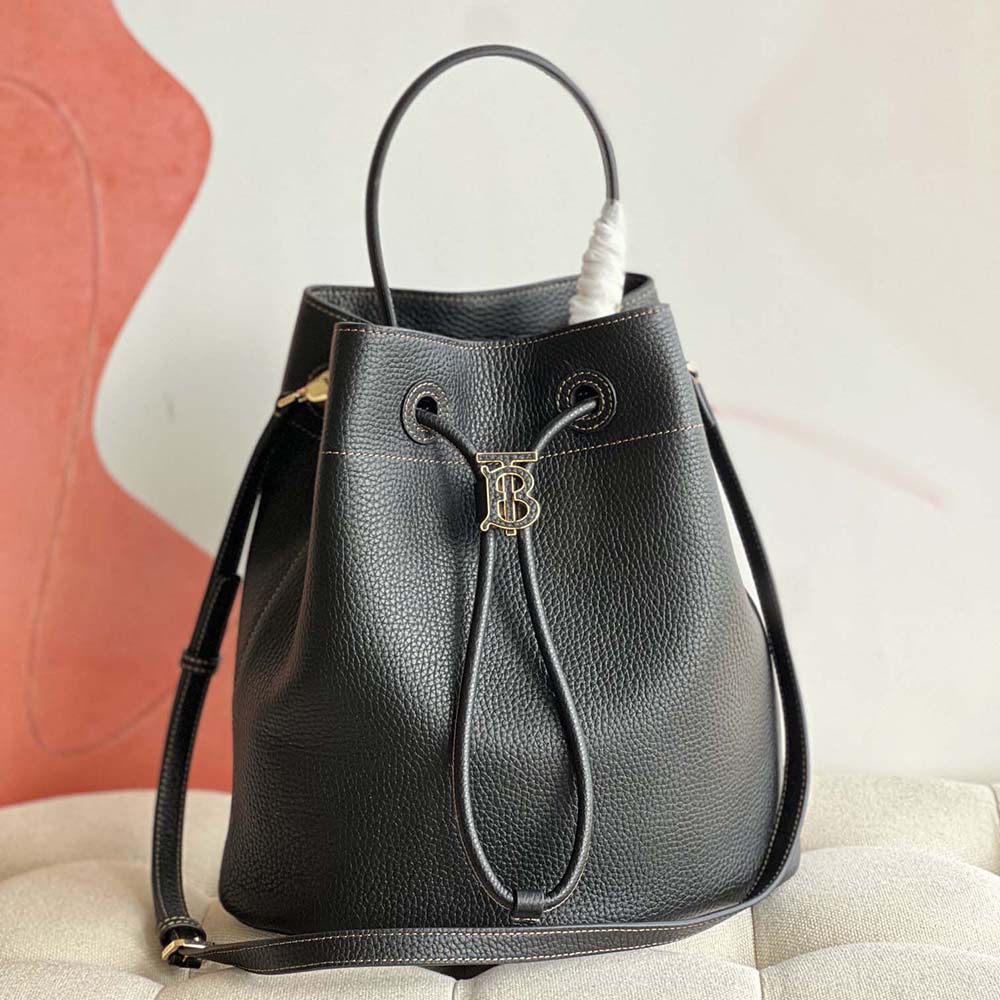 Close-up of TB monogram clasp on Burberry Women Grainy Leather Small TB Bucket Bag-Black