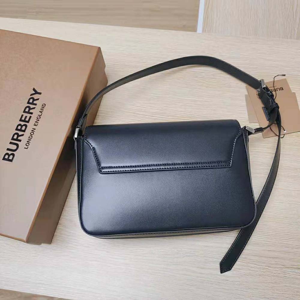 Close-up of gold hardware and Burberry check on black leather bag