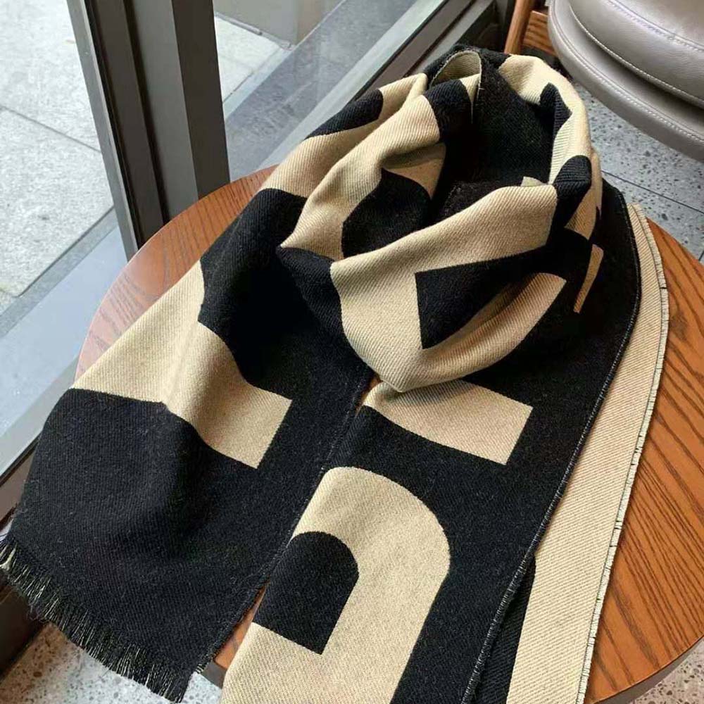Close-up detail of jacquard Burberry logo on wool scarf in brown