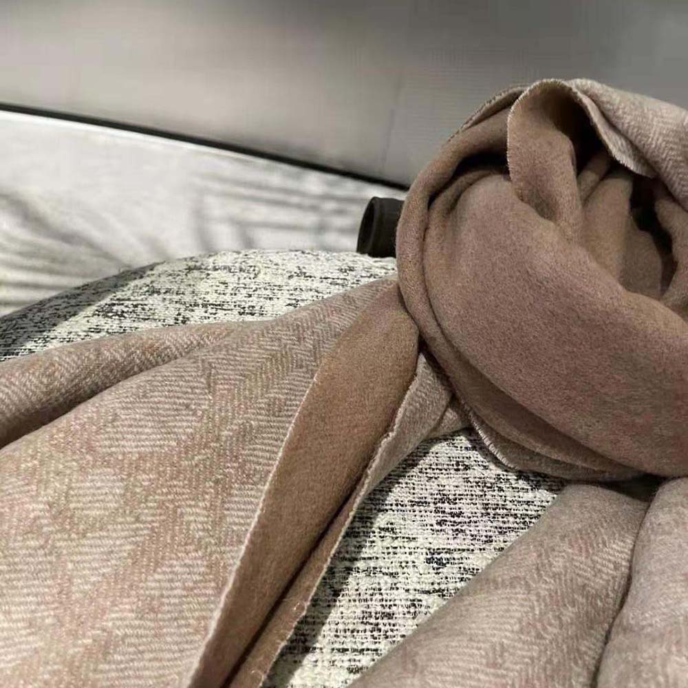 Side angle showing reversible beige and patterned sides of Dior blanket scarf