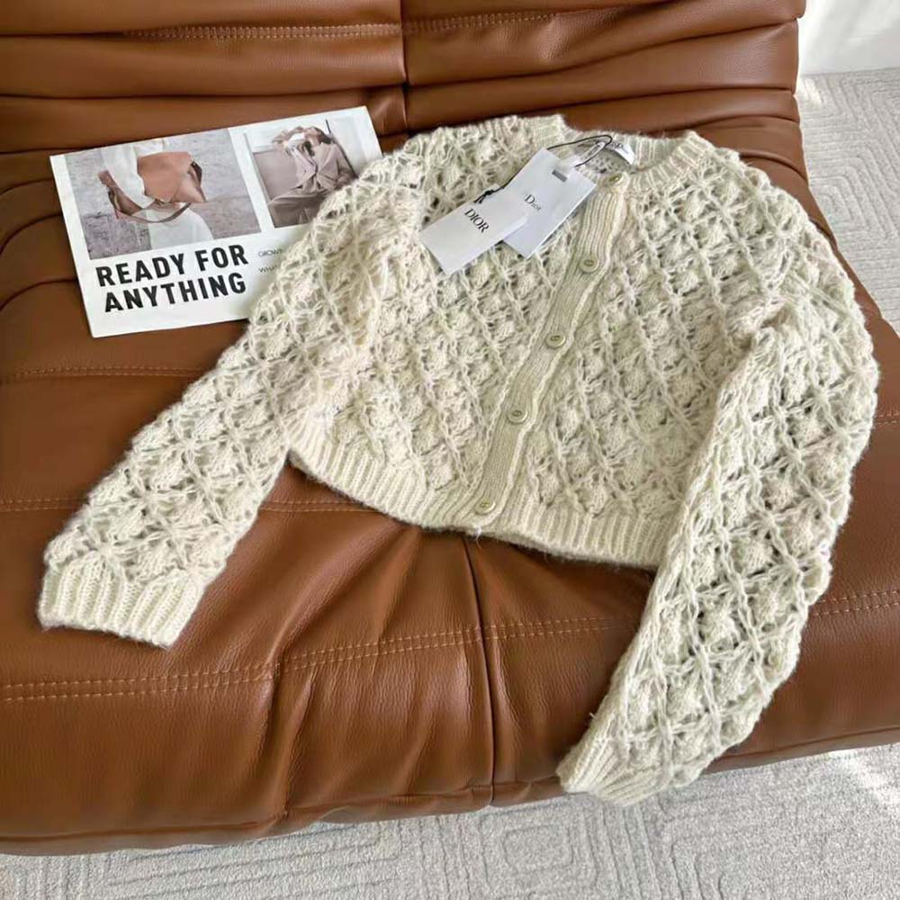 Close-up of Dior branded buttons on twin-set knit in white ecru