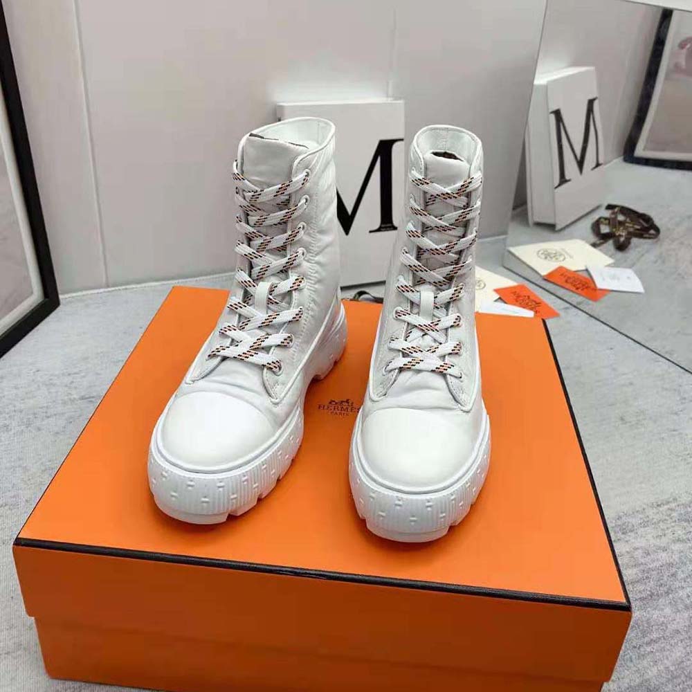 Close-up of white calf leather and Hermes embossed detail on boot