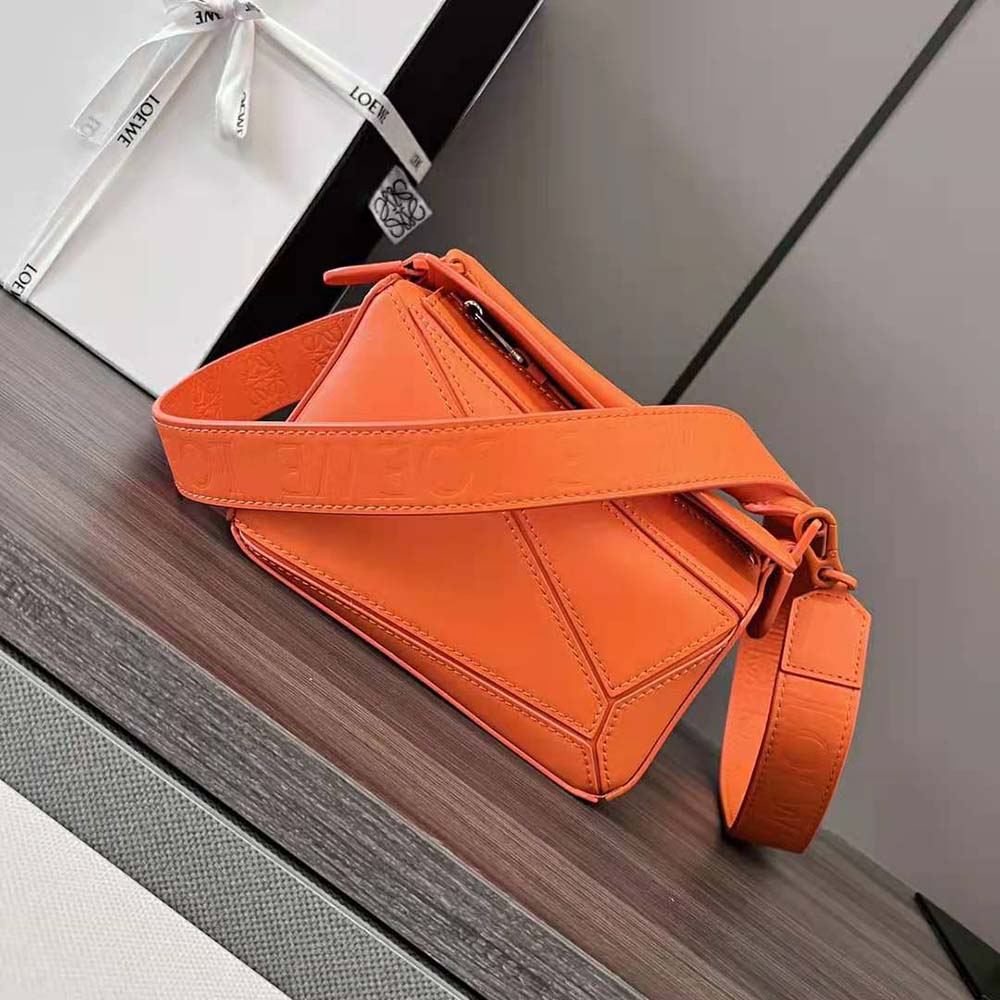 Side angle showing gold-tone hardware on Mini Puzzle Bag orange leather