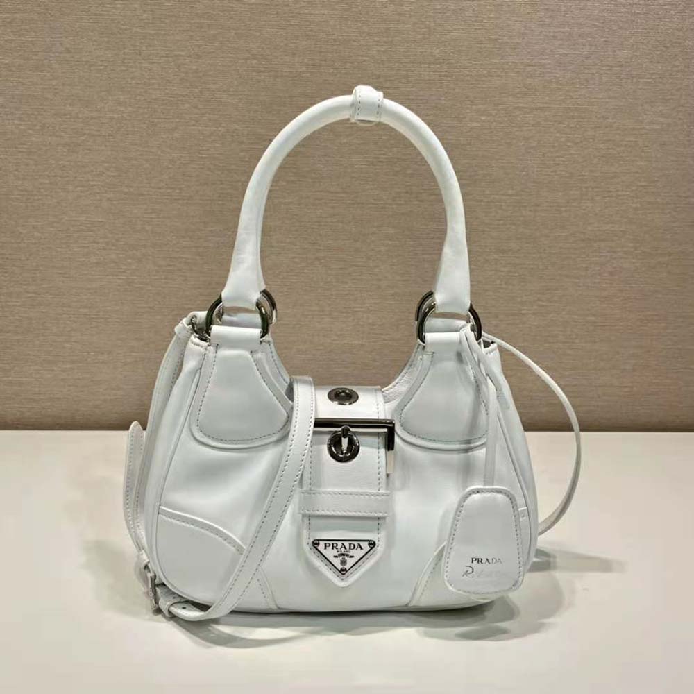 Close-up on silver Prada logo hardware on white bag