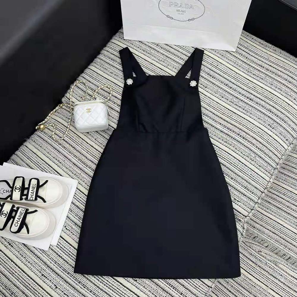 Close-up of Prada triangle logo hardware on black Re-Nylon overall dress