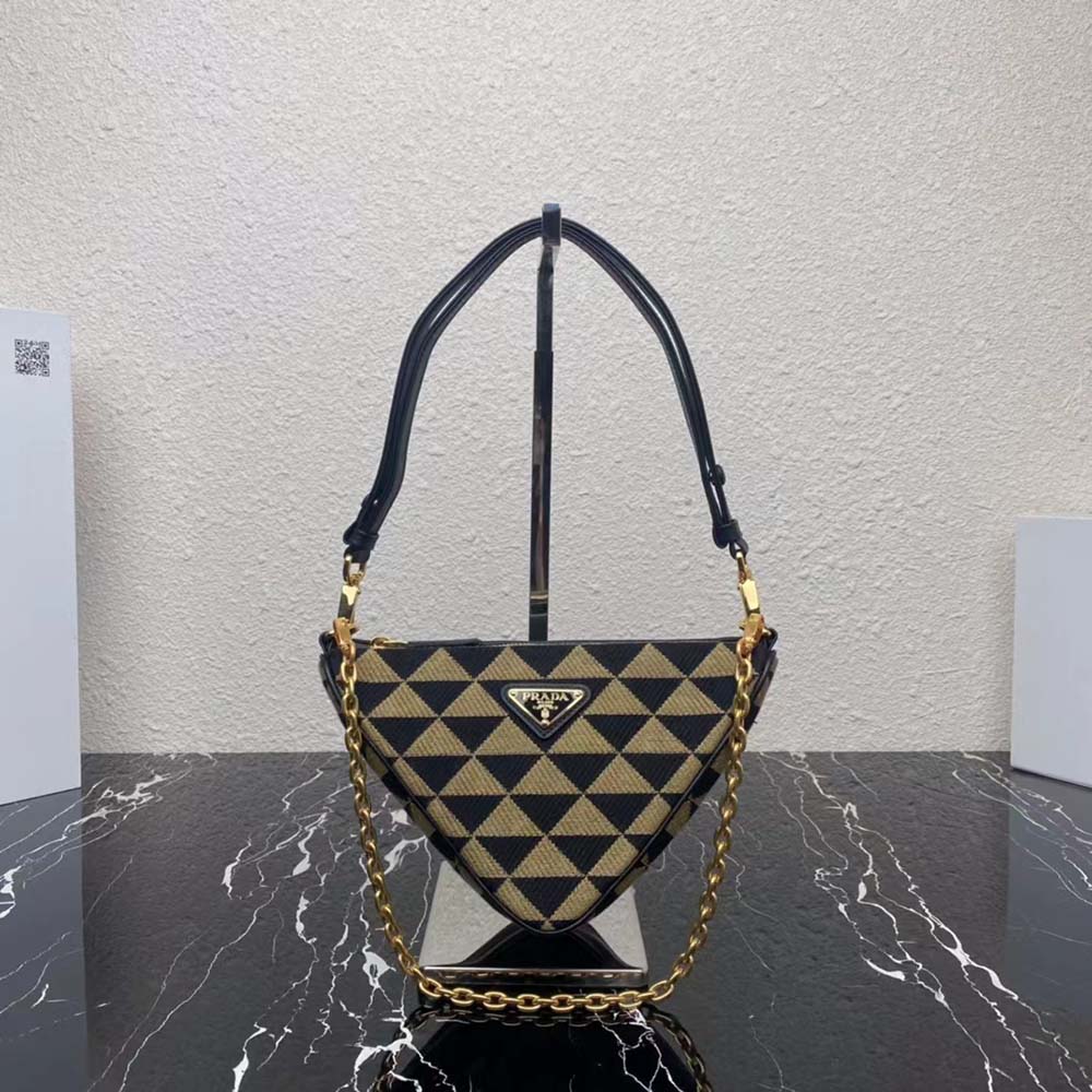 Close-up of gold Prada logo hardware on black leather mini bag