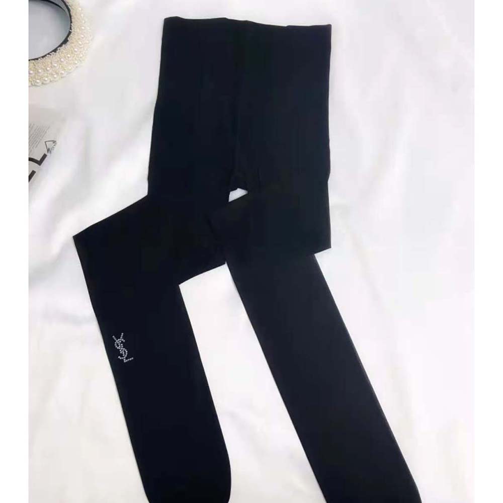Close-up detail of YSL logo on sheer black tights ankle area