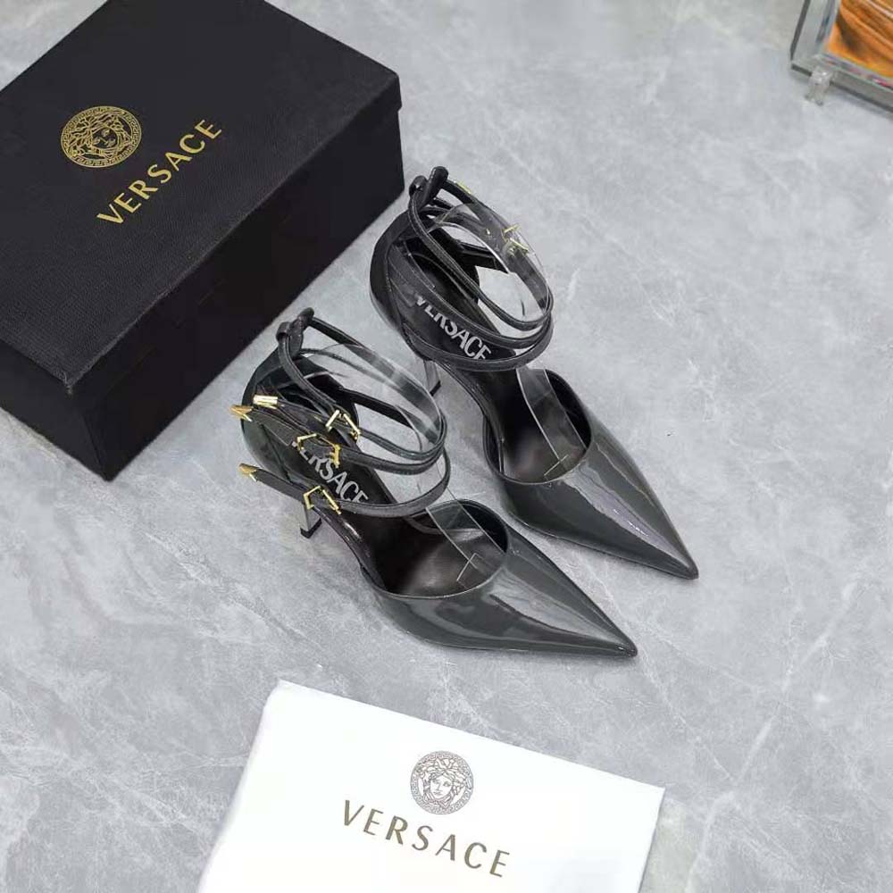 Close-up on Versace metallic logo detail on gray pumps
