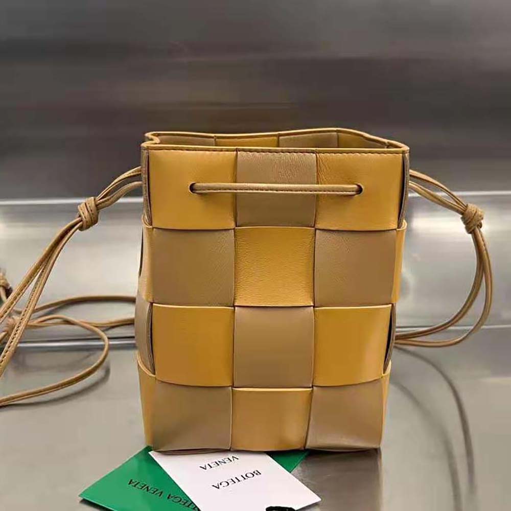 Close-up on gold-tone hardware and flap closure of the Bottega Veneta Small Cassette Bucket bag