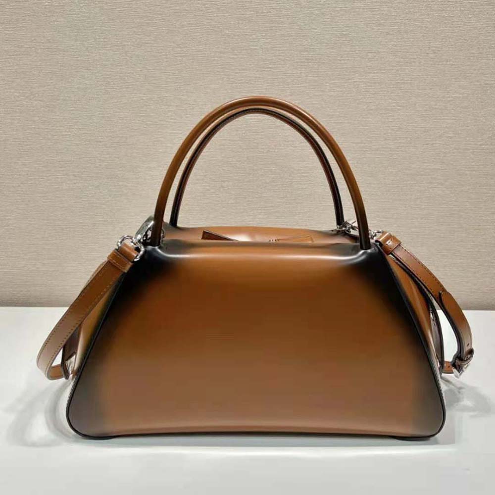Side angle highlighting Prada logo hardware on the brown handbag