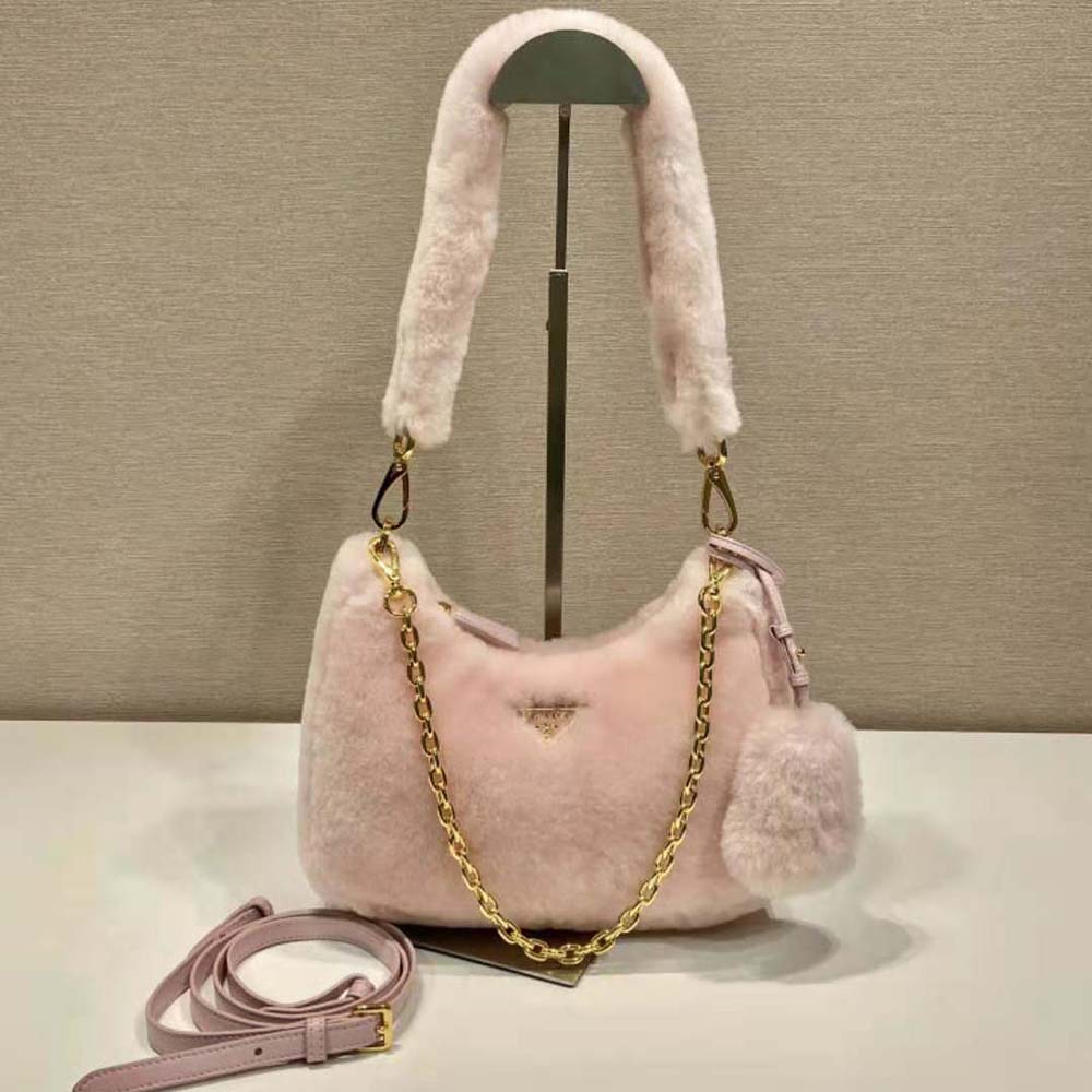 Close-up detail of pink shearling and enameled triangle logo on Prada bag