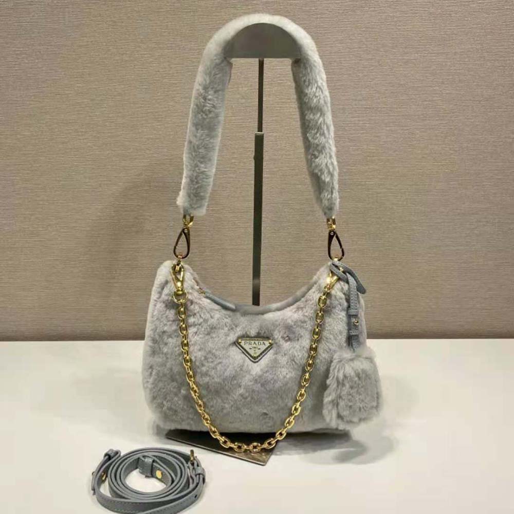 Close-up of enameled metal triangle logo on Prada Shearling Mini-Bag