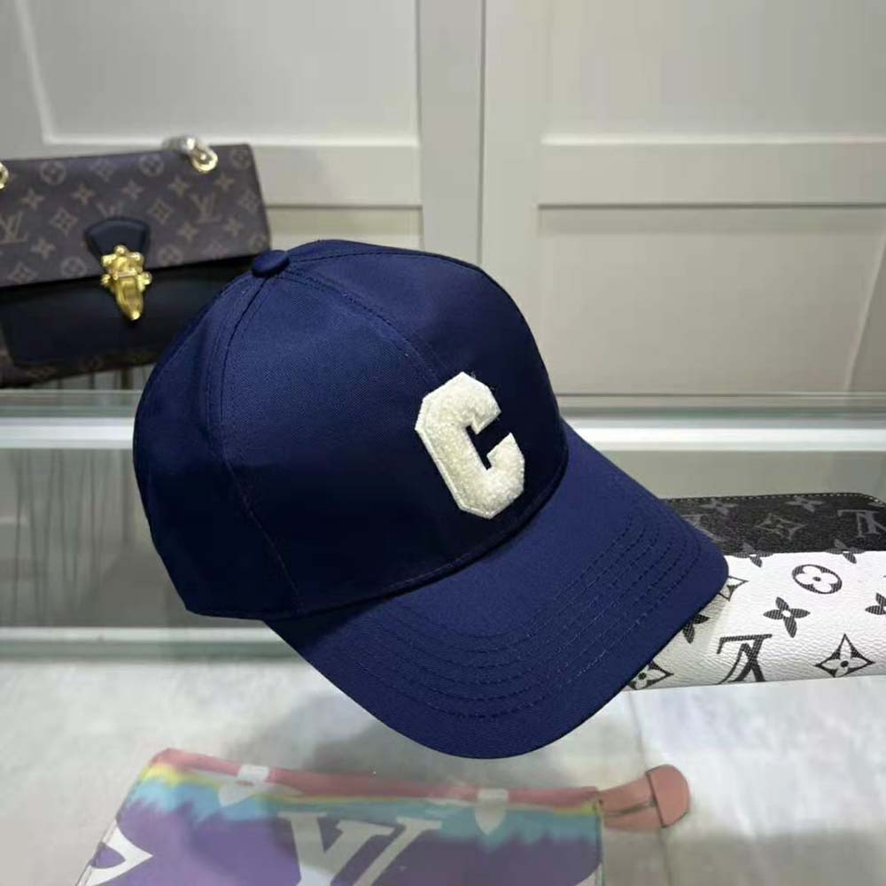 Close-up of embroidered Celine initial on navy baseball cap