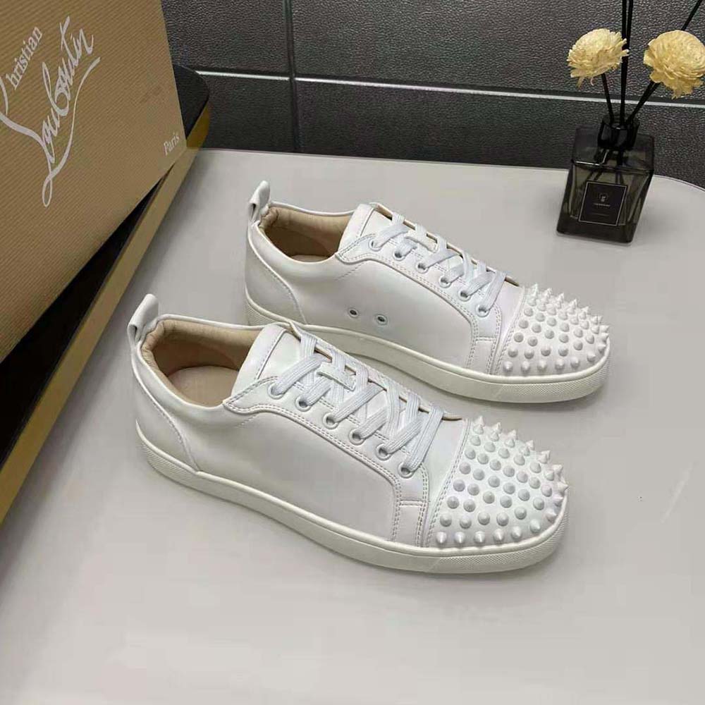 Side profile showing red sole and spike detailing on Christian Louboutin Men Louis Junior Spikes-White