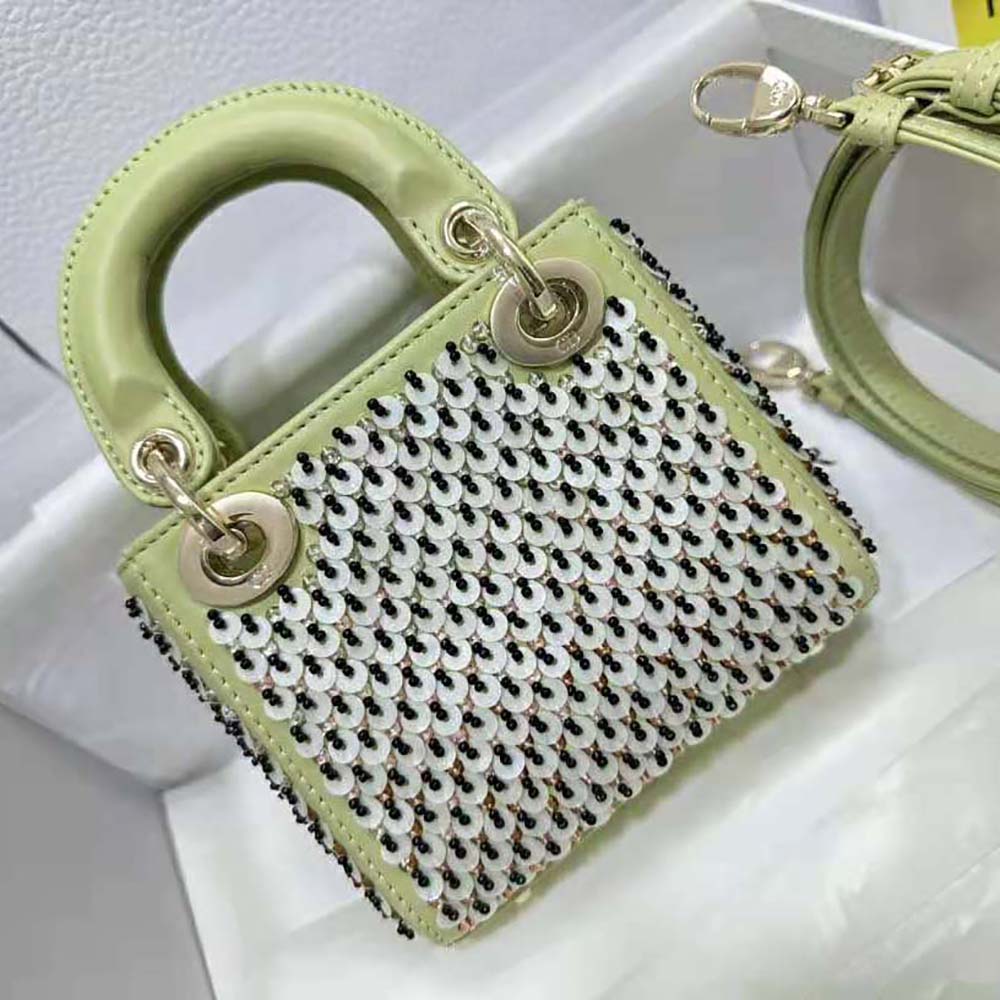 Side angle showing gold-tone hardware and signature charms on Dior Micro Lady Dior Bag