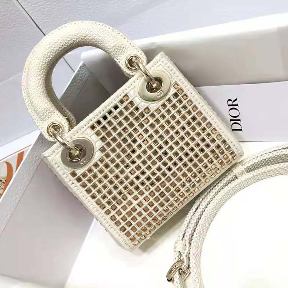 Side angle showing silver-tone hardware on mini Lady Dior bag white
