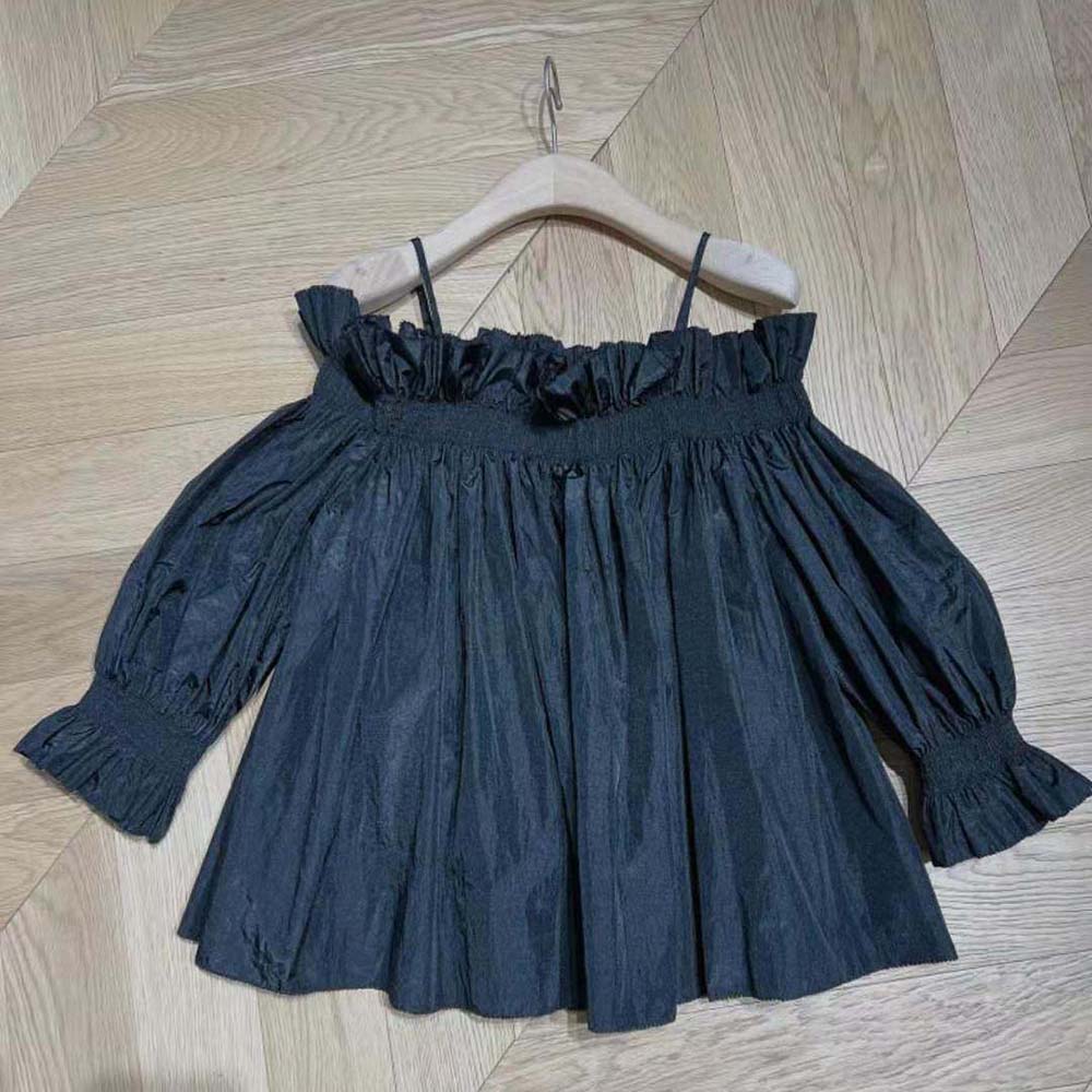 Close-up of smocked off-the-shoulder detail on Dior silk taffeta top