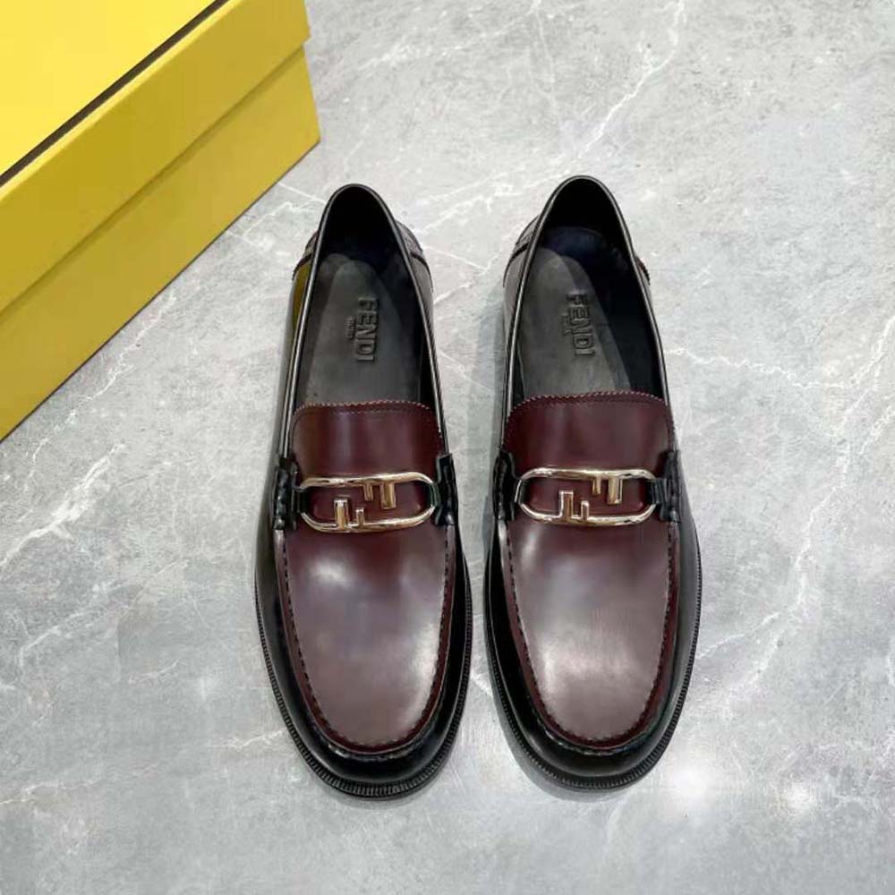 Close up on gold Fendi O’Lock hardware detail on maroon loafers