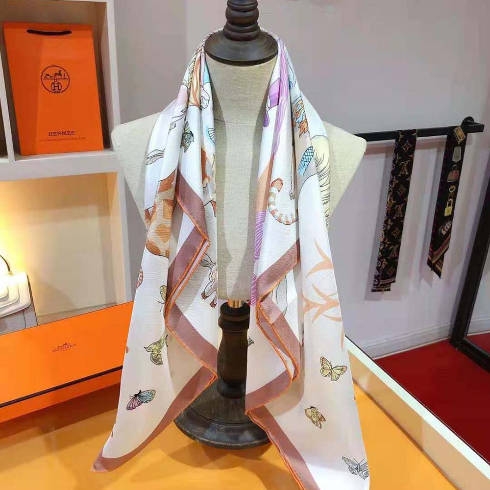 Detail of signature Hermes story print on white silk scarf