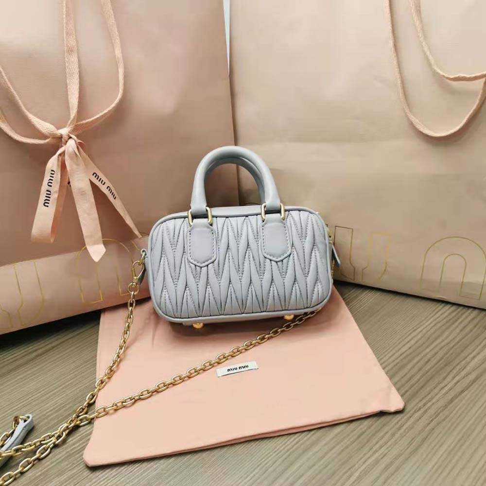 Side angle showing top handle and silver hardware of Miu Miu mini-bag
