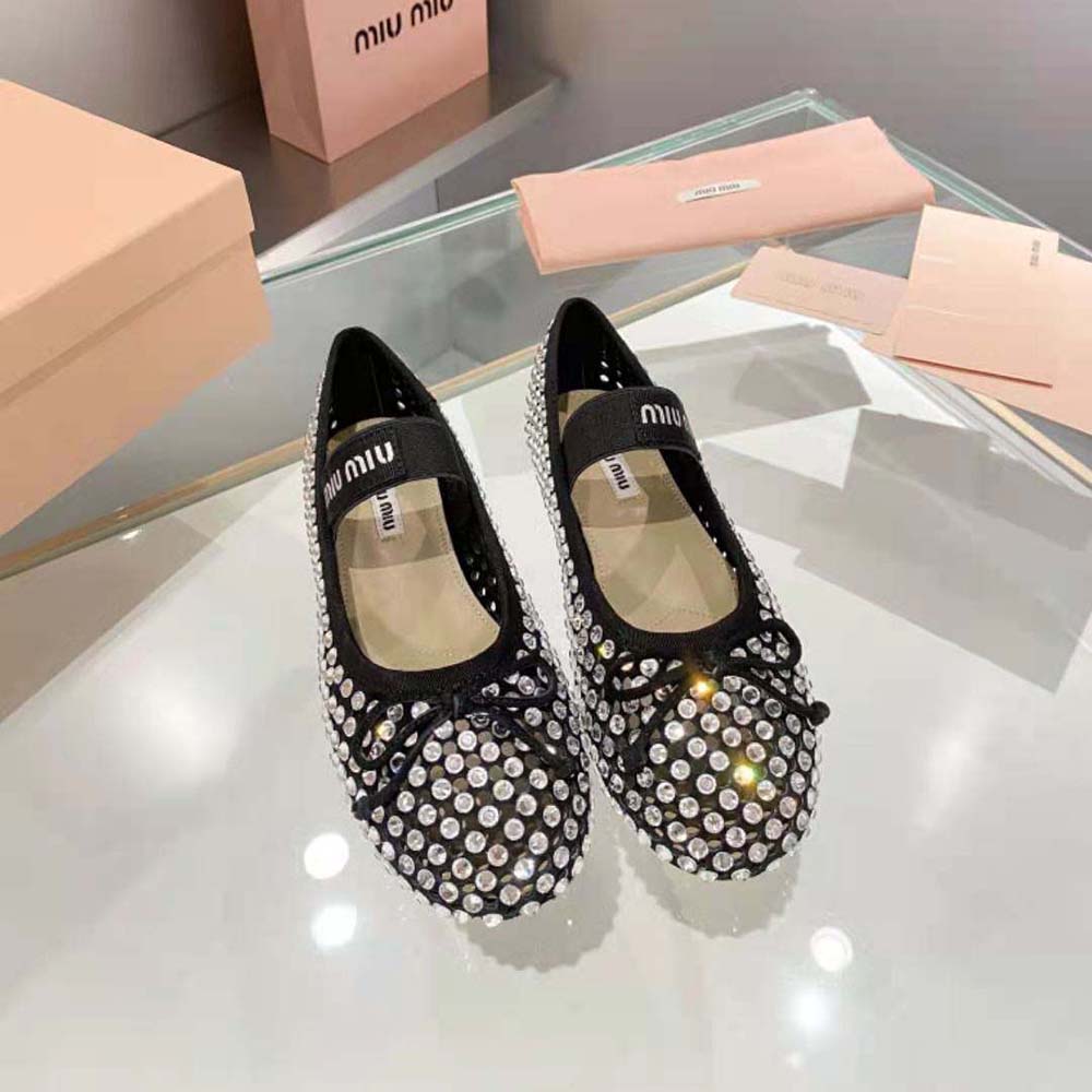 Close-up detail of satin and logo hardware on Miu Miu ballerinas