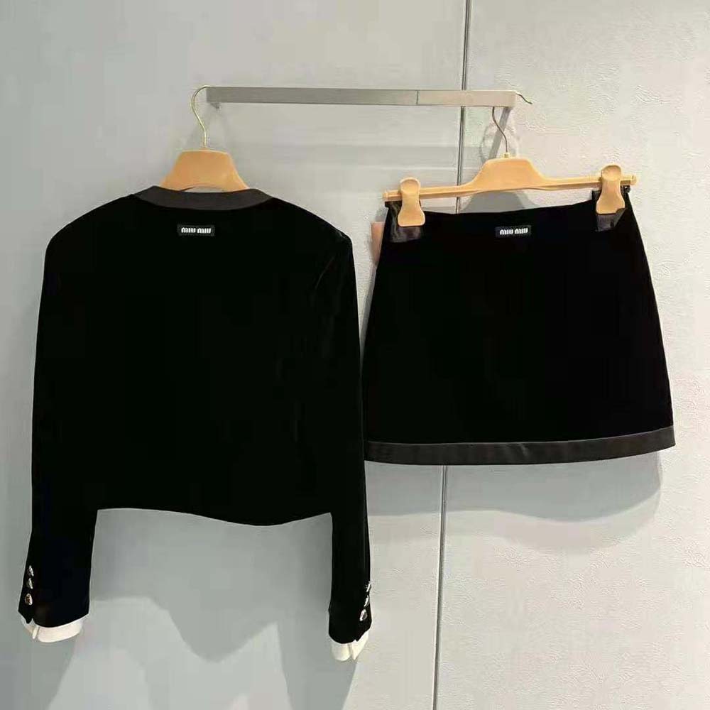 Close-up of Miu Miu logo label on black velvet jacket sleeve
