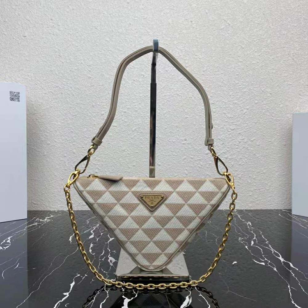 Close-up of gold-tone hardware and Prada logo on mini-bag beige fabric
