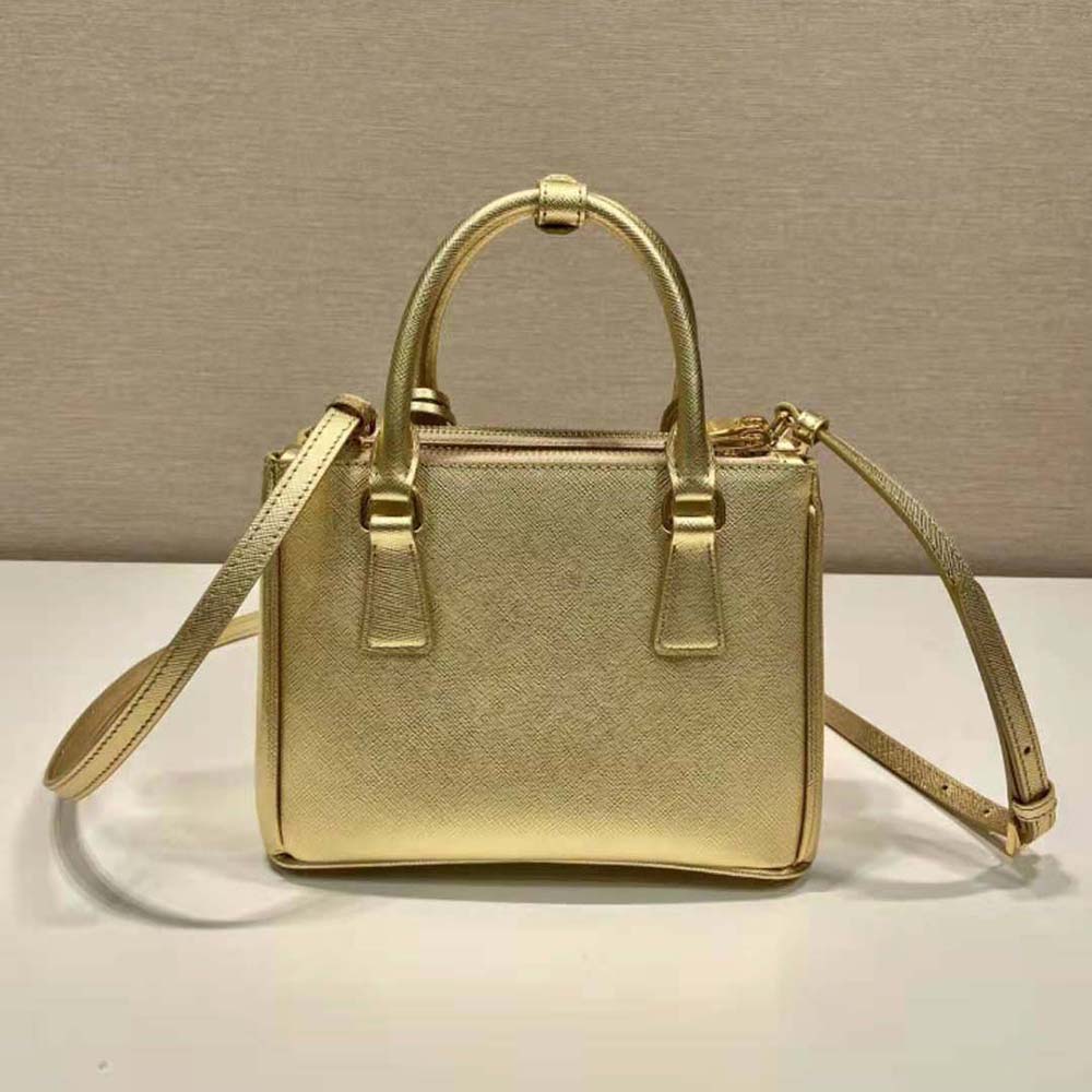 Side angle showing structured silhouette of Prada Galleria mini-bag in gold