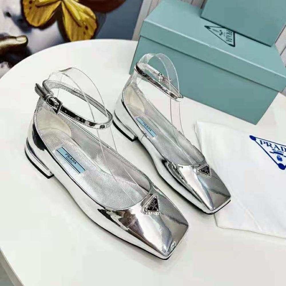Close-up of metallic leather and Prada logo hardware detail on ballerinas