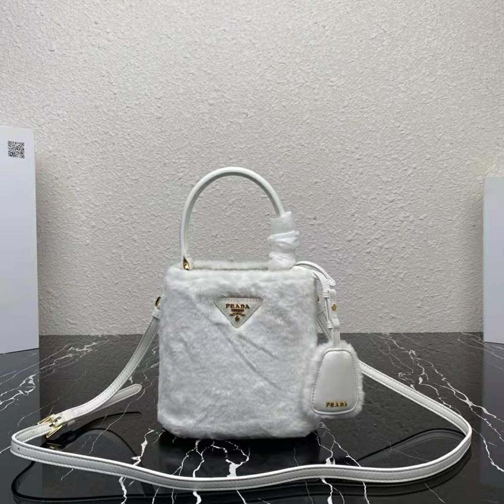 Close-up of Prada logo hardware on white shearling mini-bag