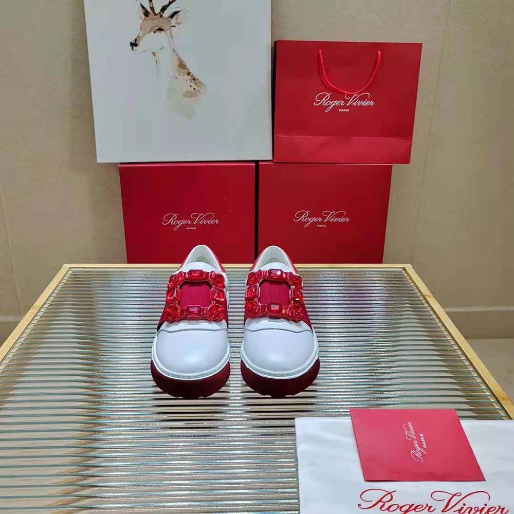 Close-up of sparkling strass buckle on red leather Roger Vivier sneakers
