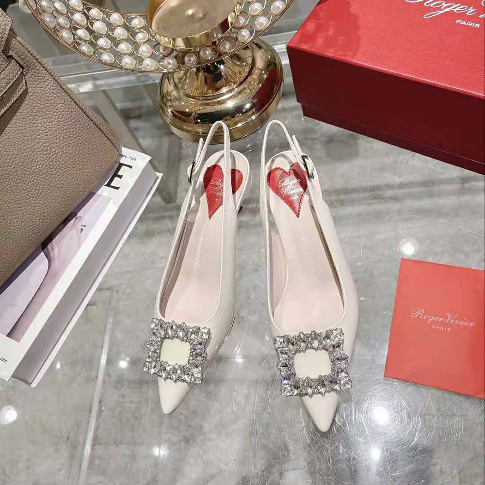 Close-up of signature strass buckle on Roger Vivier Virgule white slingbacks