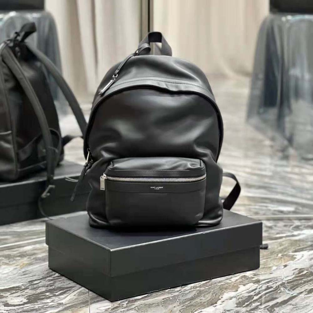Close-up of gold YSL logo hardware on backpack front