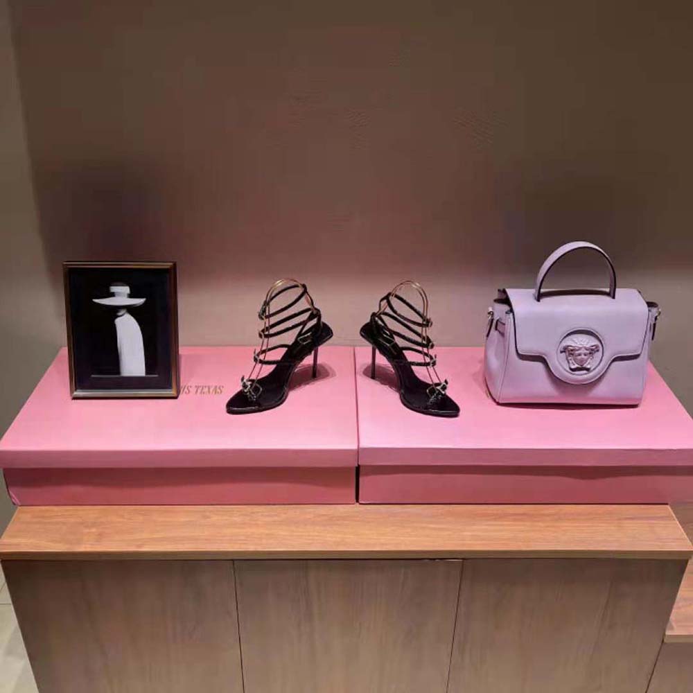 Close-up on signature YSL hardware detail on pink lacquered Ayers sandals