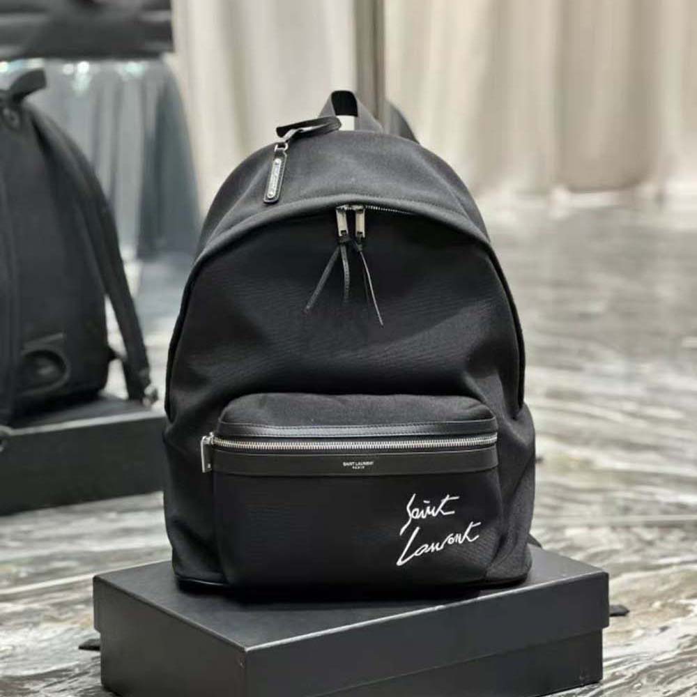 Close-up of silver YSL embroidered logo on black canvas backpack
