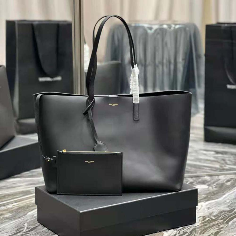 Close-up of gold YSL logo and closure on black leather shoulder bag