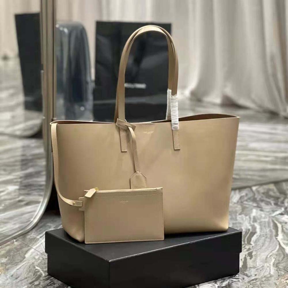 Close-up of gold YSL logo hardware on Sandy leather bag